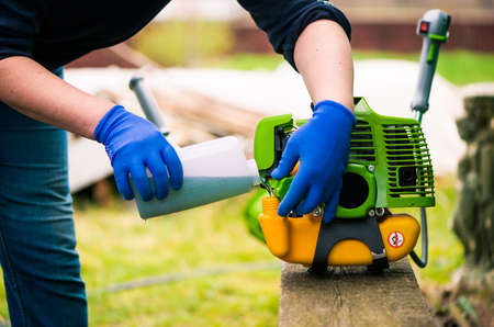 grass-cutter preparing to work on spring farmland soilの写真素材