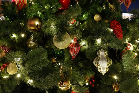 Red and gold retro vintage christmas decorations on a christmas tree with lights