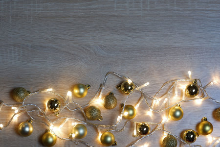 New year christmas composition from golden shiny and matte balls on light oak wood background with...