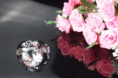 Three excellent diamonds of the first water and bouquet of pink roses with reflection on black mirror background close up view. Jewelry diamonds sale, invitation, action, discount banner, poster templateの写真素材