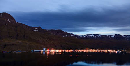 Nighttime view of town of Seydisfjordur and the fjord in Eastern Icelandの写真素材