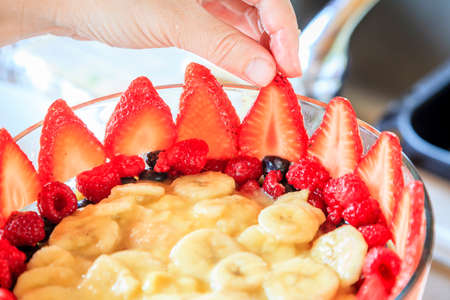 Closeup image of trifle being prepared in a glass bowlの写真素材