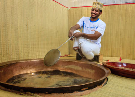 NIZWA, OMAN, MAY 27, 2016: factory worker skims foam from sugar syrup as part of process of making traditional Omani halwaのeditorial素材