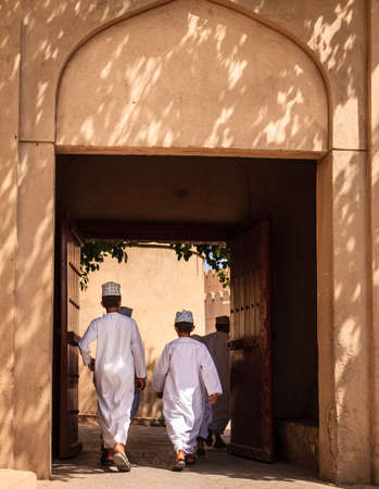 NIZWA, OMAN, MAY 27, 2016: Omani boys are walking through an alley in the old part of Nizwa village in Omanのeditorial素材