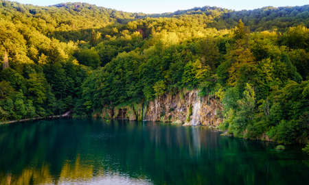 Waterfall reflecting in a lake in the evening at Plitvice Lakes National Parkの写真素材