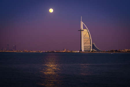 Dubai, UAE, December 13, 2016: full moon is rising over Burj Al Arab - the world's only 7-star luxury hotelのeditorial素材