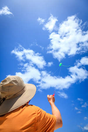 A man is flying a kite on a tropical beach in the Caribbeanの写真素材
