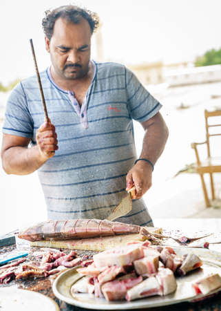 Dibba, Al Fujairah, UAE, November 25, 2016: a local fisherman cleaning fish near Dibba Port, UAEのeditorial素材