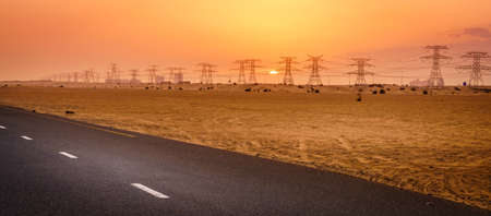 Scenic view of sunset over power lines in the desert in Dubai, UAEの写真素材