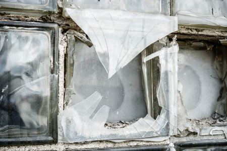 Close-up image of a broken glass box window in an abandoned building