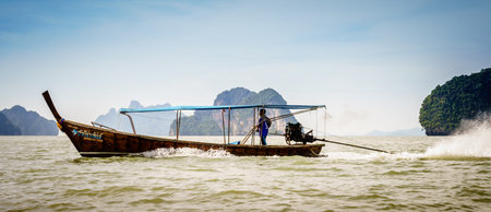 Andaman Sea, Thailand, November 6, 2017: Traditional Thai motor boat is speeding by between the...