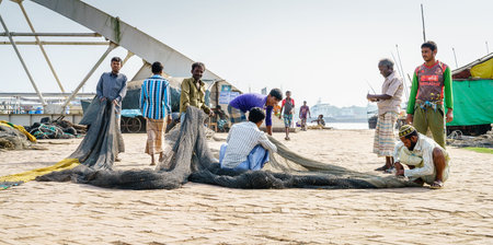 Chittagong, Bangladesh, December 22, 2017: Fishermen working with the nets in a park near the...