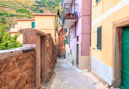 View down a narrow residential street in the village of Manarola in Cinque Terre National Park, Italyの写真素材