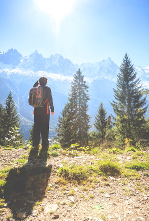 A young woman is hiking in the mountains near a ski resort town of Chamonix in Franceの写真素材