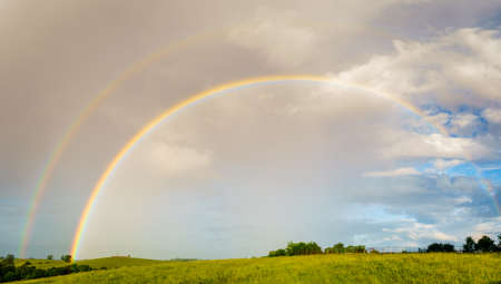 Panoramic view of Central Kentucky countryside with double rainbow after stormの写真素材
