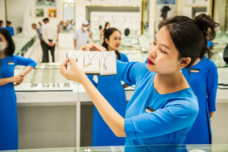 Ha Long City, Vietnam, November 16, 2022: A sales lady demonstrates cultured pearl jewelry in a shop...