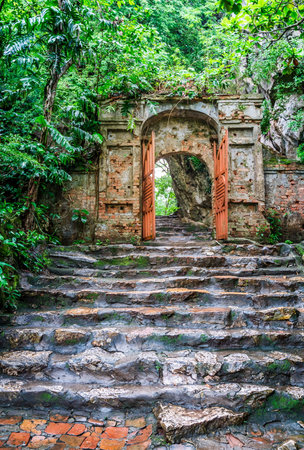 Old stone steps and a gate leading to the Marble Mountain in Vietnamの写真素材
