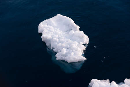 Big piece of ice in deep blue waterの写真素材