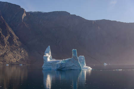 Greenland landscape with beautiful coloured rocks and iceberg.の写真素材