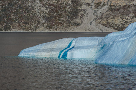 Greenland landscape with beautiful coloured rocks and iceberg.