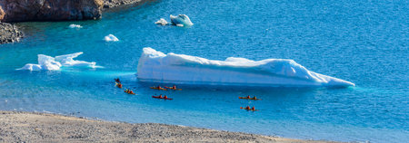 Kayaking in Arctic sea near icebergの写真素材
