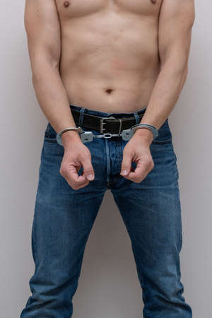 Adult prisoner male hands with handcuffs. Arrested man. Criminal concept.の写真素材