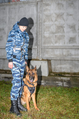 Female police officers with a trained dog. German shepherd police dog.