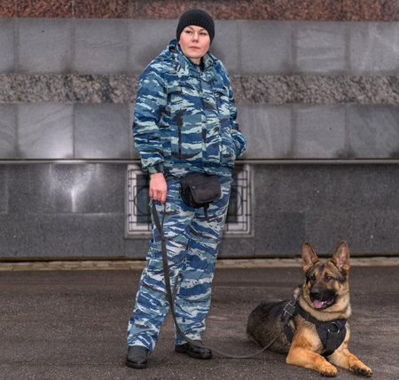 Female police officers with a trained dog. German shepherd police dog.