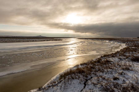 Arctic landscape in winter time. Small river with ice in tundra.の写真素材