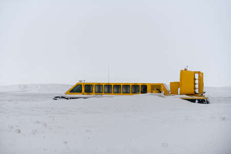 Hovercraft in winter tundra. Air cushion on the beach. Yellow hover craft under snow.の写真素材