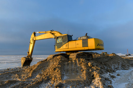 Yellow excavator working on construction site. The road construction.の写真素材