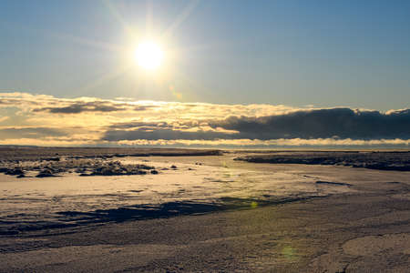 Arctic landscape in winter time. Small river with ice in tundra.の写真素材