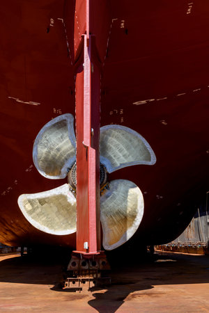 Cargo vessel in dry dock on ship repairing yard. Variable pitch propeller and rudder.