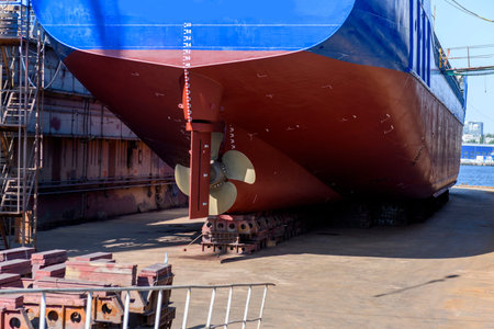 Cargo vessel in dry dock on ship repairing yard. Variable pitch propeller and rudder.