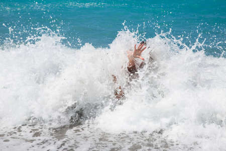 single hand of drowning man in sea asking for helpの写真素材