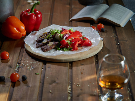 Fried beef pieces are served with garlic and red bell pepper.の写真素材