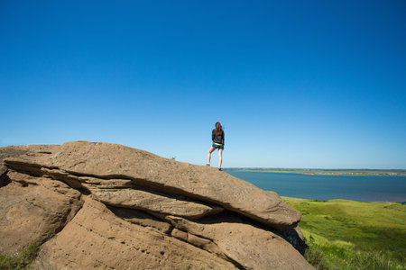 girl on top of the mountain admiring viewの写真素材