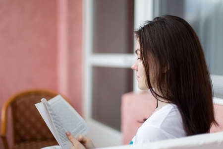 girl reading a book closeup with shallow depth of field focus on the bookの写真素材