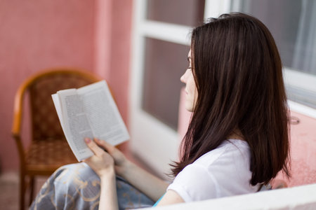girl reading a book closeup with shallow depth of field focus on the bookの写真素材