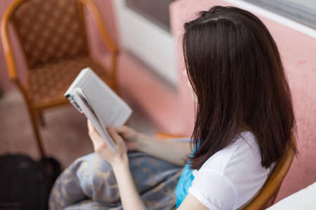 girl reading a book closeup with shallow depth of field focus on the bookの写真素材