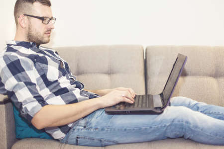 the man on the couch with a laptopの写真素材