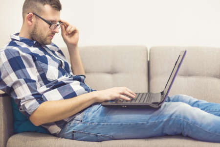 the man on the couch with a laptopの写真素材