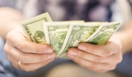 male hands holding dollar bills on a blurred background