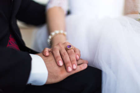 the hands of the bride and groom with a ring in their armsの写真素材