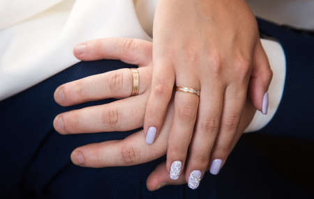 the hands of the bride and groom with a ring in their armsの写真素材
