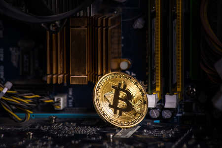 gold coin bitcoin on the motherboard among computer componentsの写真素材