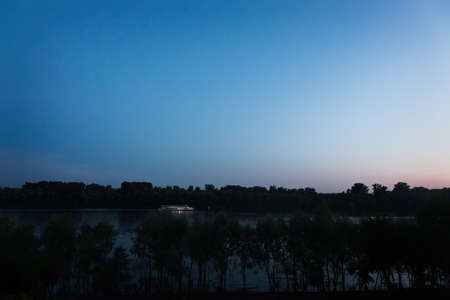 a lonely pleasure boat on the river at night. Overall planの写真素材