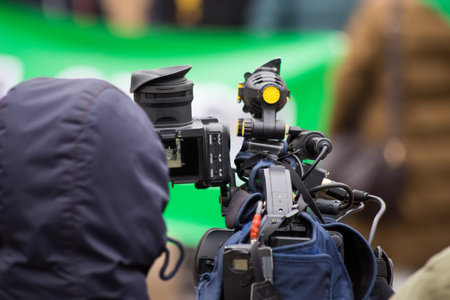 The cameraman shoots a report on a professional video camera from a tripod. street report.
