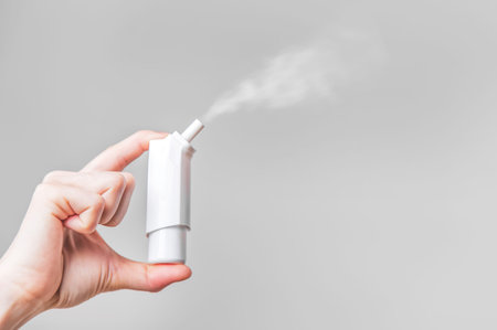 Female hand spray for throat on white background isolation