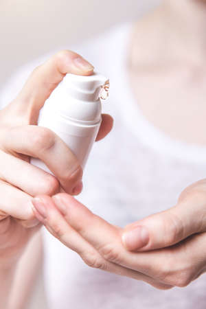 Women's hands using wash hand sanitizer gel pump dispenser.の写真素材